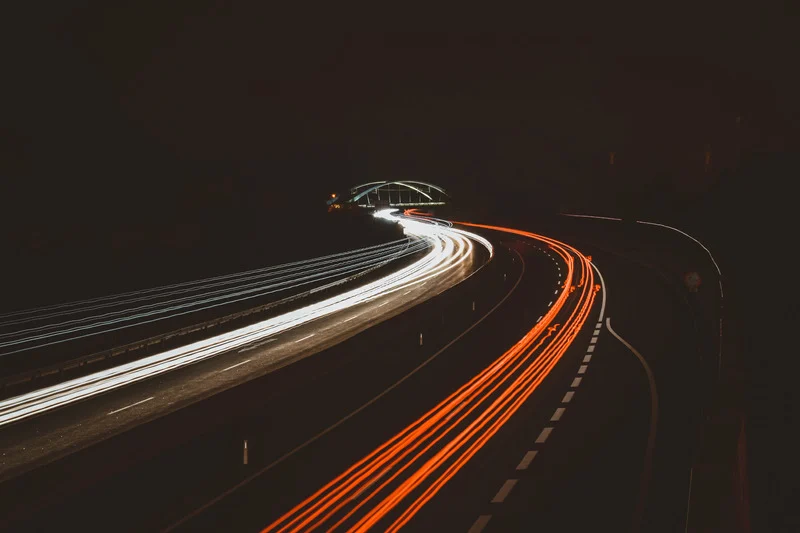 Carros passando rápido em uma avenida.